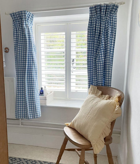 window with blue curtains and white hardwood shutters