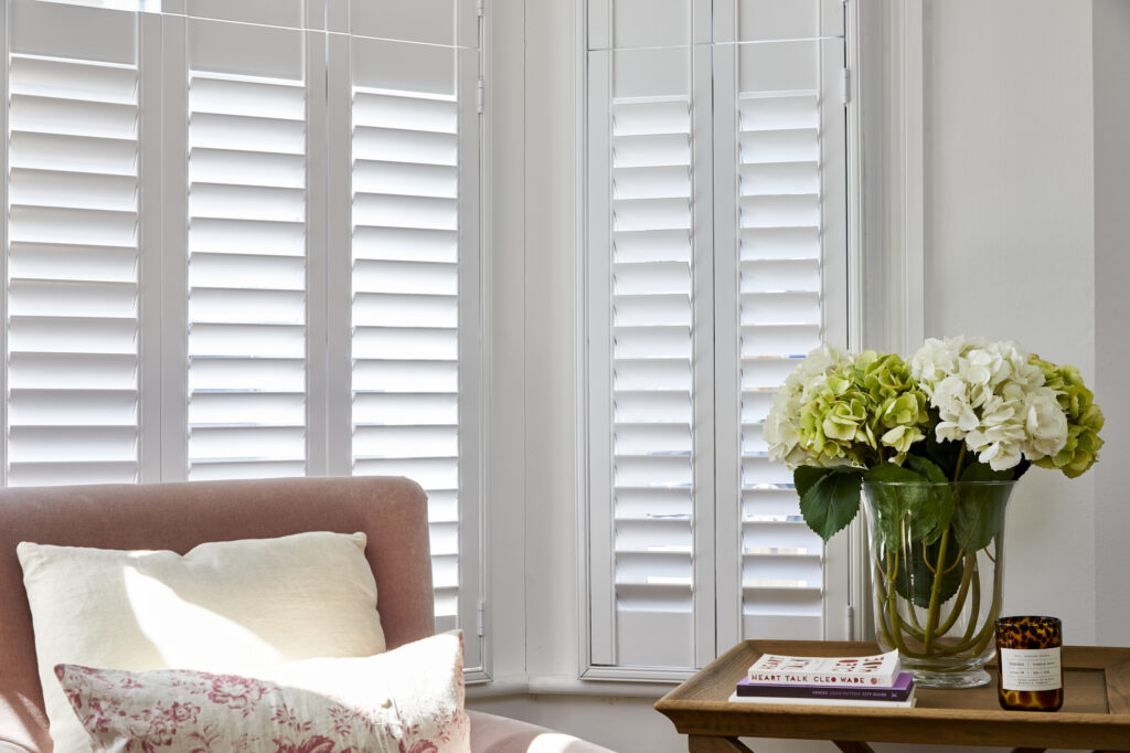 image showing a hous with plantation shutters, which can help reduce the enrgy bills by improving the insulation of large windows