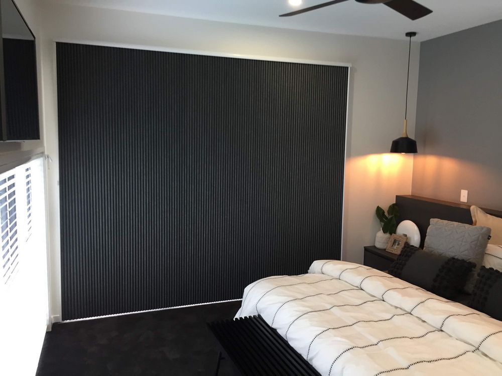 bedroom with a black vertical honeycomb blind